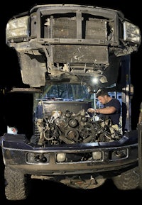 a man working on the engine of a truck