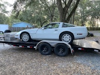 a white sports car on a flatbed trailer