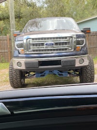 a ford f-150 pickup truck is parked in a driveway