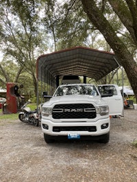 a white truck parked under a tree
