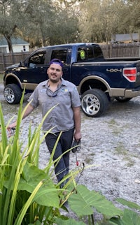 a man standing in front of a truck and plants