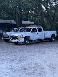two white trucks parked next to each other