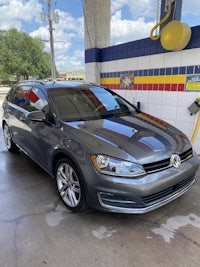 a gray volkswagen golf parked at a gas station