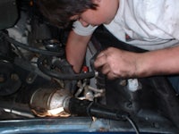 a boy is working on a car