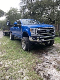a blue ford super duty parked in the grass