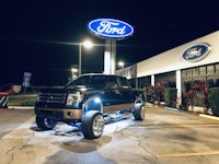 a ford f-150 parked in front of a ford dealership