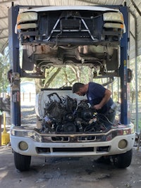 a man working on the engine of a truck